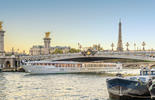 Inland ferry passing by a bridge in paris